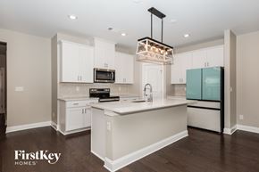 Hermitage house for rent - A kitchen with a white island and a black stove top oven.