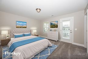 Hermitage house for rent - A bedroom with a large bed and a painting on the wall.