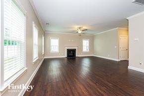 Clemmons house for rent - A spacious living room with wood floors and a fireplace.