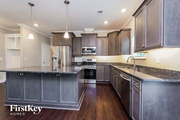 Clemmons house for rent - A modern kitchen with dark wood cabinets and stainless steel appliances.