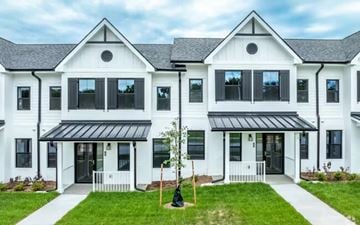 Ames townhouse for rent - A white two-story house with black roofing and a black awning.