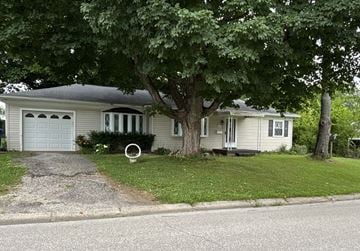 Sellersburg house for rent - A house with a white fence and a tree in front.