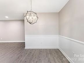 Charlotte apartment for rent - A room with a wooden floor and a chandelier hanging from the ceiling.