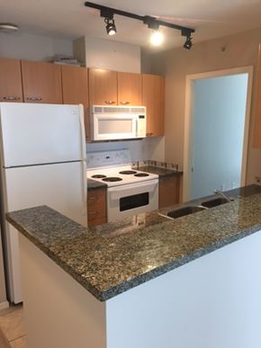 Vancouver apartment for rent - A kitchen with granite countertops and white appliances.