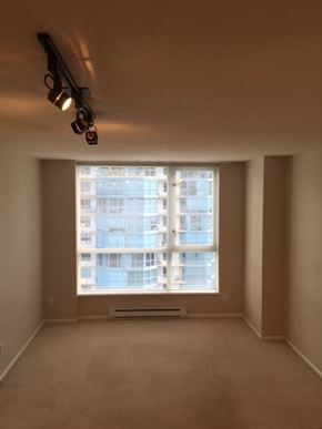 Vancouver apartment for rent - A room with a large window overlooking a building.