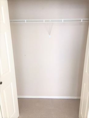Vancouver apartment for rent - A white door is open to a room with a white wall and a white shelf.