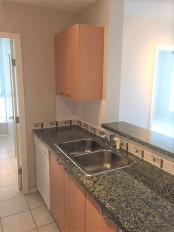 Vancouver apartment for rent - A kitchen with a granite counter top and a sink.