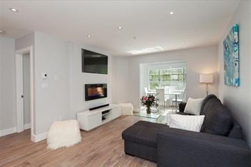 Vancouver apartment for rent - A modern living room with a grey couch and a white coffee table.