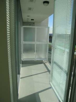 Vancouver apartment for rent - A hallway with a glass wall and a white floor.