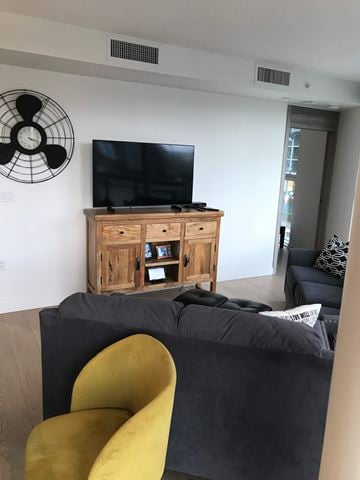 Vancouver apartment for rent - A living room with a yellow chair and a black couch.