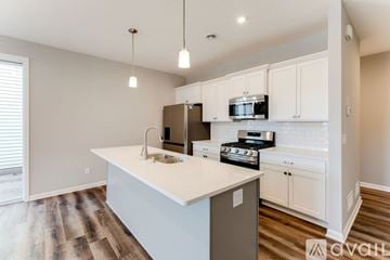 Ramsey house for rent - A kitchen with white cabinets and a wooden floor.