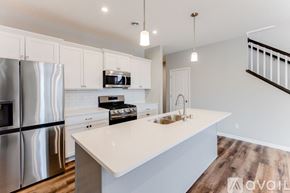 Ramsey house for rent - A modern kitchen with stainless steel appliances and white countertops.