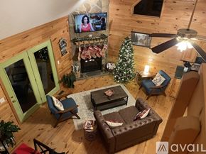 Blairsville house for rent - A living room with a television, a couch, a chair, a coffee table, and a Christmas tree.