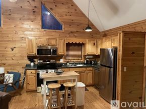 Blairsville house for rent - A kitchen with wooden cabinets and a stainless steel refrigerator.
