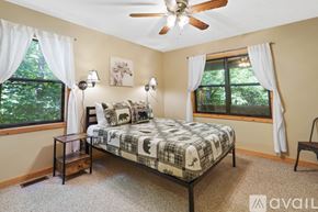 Blairsville house for rent - A bedroom with a bed, nightstand, and window.