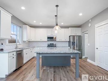 Le Claire house for rent - A kitchen with a table in the middle and a fridge to the side.