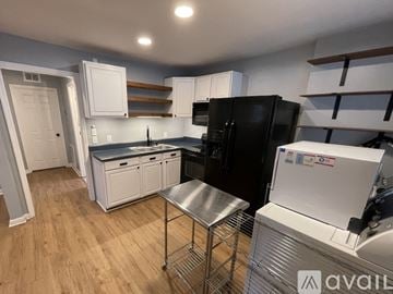 Nashville house for rent - A kitchen with white appliances and wooden floors.