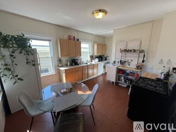 Somerville apartment for rent - A kitchen with a table and chairs in the foreground and a potted plant on the left.