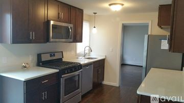 Boston apartment for rent - A kitchen with dark wood cabinets and stainless steel appliances.