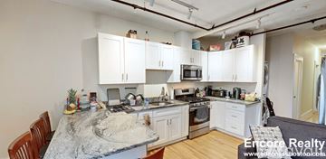 Cambridge apartment for rent - A kitchen with white cabinets and a granite countertop.
