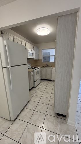 Hallandale Beach apartment for rent - A kitchen with a white refrigerator and white tiled floor.