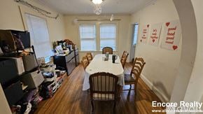 Boston house for rent - A dining room with a table and chairs and a sign on the wall that says "good food mood".