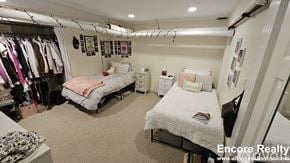 Boston house for rent - A bedroom with two beds and a closet full of clothes.