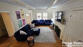 Boston house for rent - A living room with a blue couch and a grey rug.