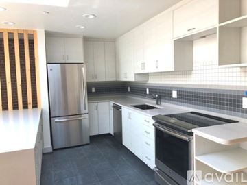 Boston apartment for rent - A kitchen with a stainless steel refrigerator and black countertops.