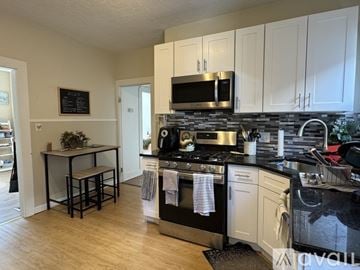 Somerville apartment for rent - A kitchen with white cabinets and black countertops.