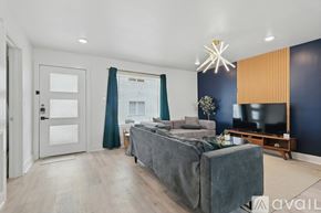 Dallas apartment for rent - A modern bedroom with a grey bed and a grey sofa.