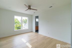 Dallas townhouse for rent - A spacious room with a ceiling fan and wooden flooring.