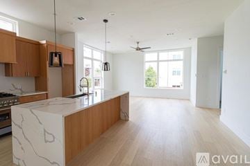 Dallas townhouse for rent - A modern kitchen with wooden cabinets and a marble island.