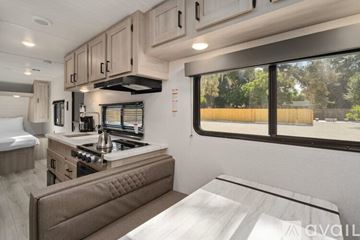 Mount Dora apartment for rent - A modern kitchen with a stove top oven and a window overlooking a wooded area.