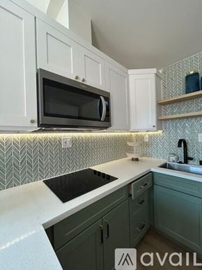 Ontario townhouse for rent - A kitchen with a black microwave above a black countertop.