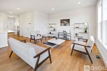 Capitol Heights house for rent - A living room with white furniture and a wooden floor.