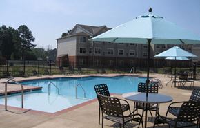 Hampton apartment for rent - a swimming pool with tables and chairs and umbrellas
