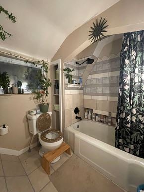 Greensburg house for rent - A bathroom with a toilet, a bathtub, and a plant.
