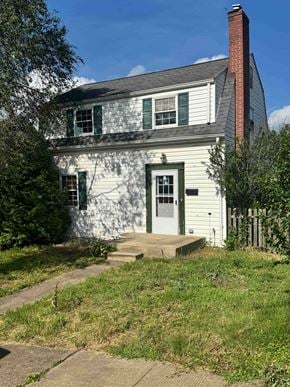 Greensburg house for rent - A white house with a grey roof and a red brick chimney.