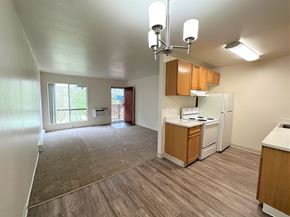 San Jose apartment for rent - A kitchen with white appliances and wooden cabinets.