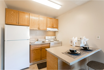 San Jose apartment for rent - A kitchen with a white refrigerator and wooden cabinets.