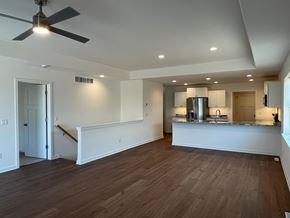 Belgium apartment for rent - A room with a ceiling fan and wooden flooring.