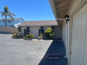 Grover Beach apartment for rent - A house with a driveway and a palm tree in the background.