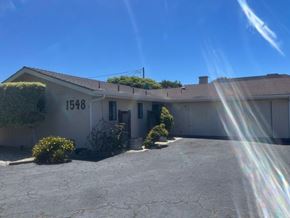 Grover Beach apartment for rent - A house with the number 1548 on it has a driveway and bushes in front.