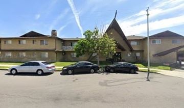 Covina apartment for rent - Two cars are parked in a parking lot in front of a building.