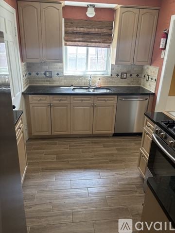 Grosse Pointe Woods house for rent - A kitchen with wooden cabinets and a black countertop.