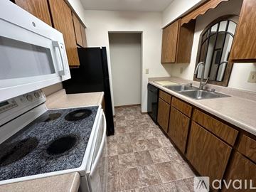 Middleton apartment for rent - A kitchen with a white stove top oven and black refrigerator.