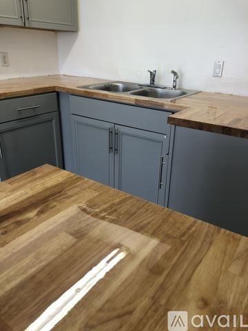 Las Vegas apartment for rent - A kitchen with a wooden countertop and grey cabinets.