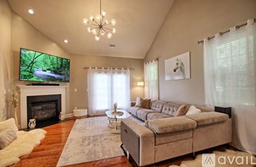 Arden house for rent - A living room with a fireplace and a television on the wall.