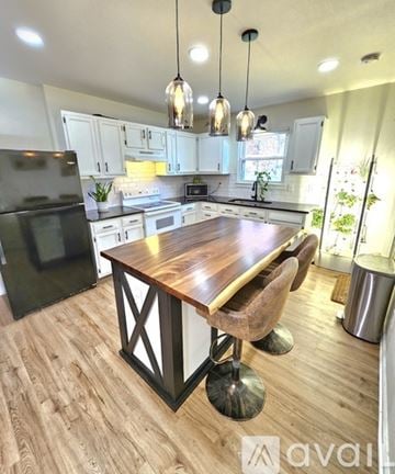 Knoxville house for rent - A kitchen with a wooden table and black fridge.